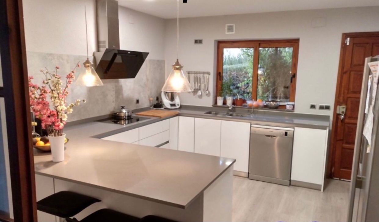 Cocina realizada por Grupo Diper con península y mobiliario blanco